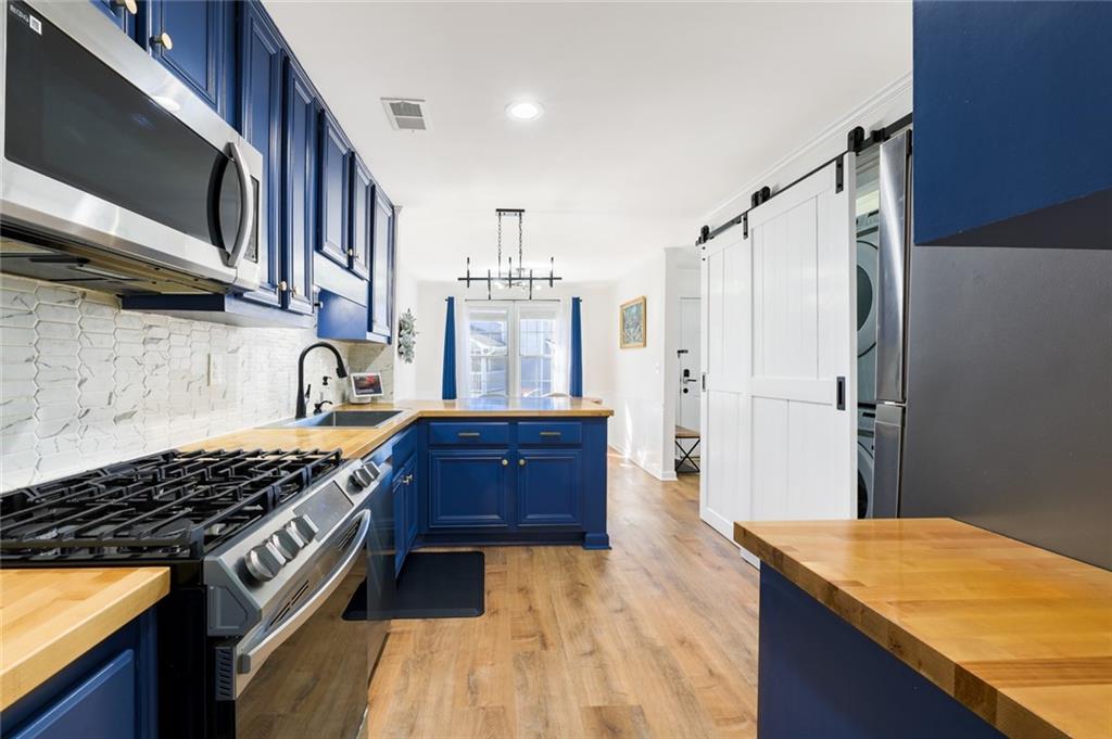 404 Countryside Place Smyrna, GA 30080 - Photo 14 of 36 a kitchen with stainless steel appliances granite countertop a stove a sink and a microwave