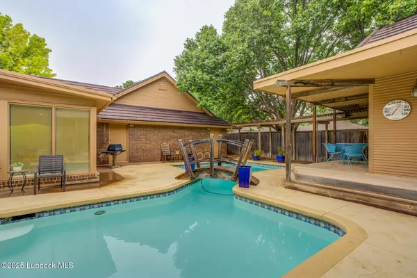 a view of a house with swimming pool and sitting area