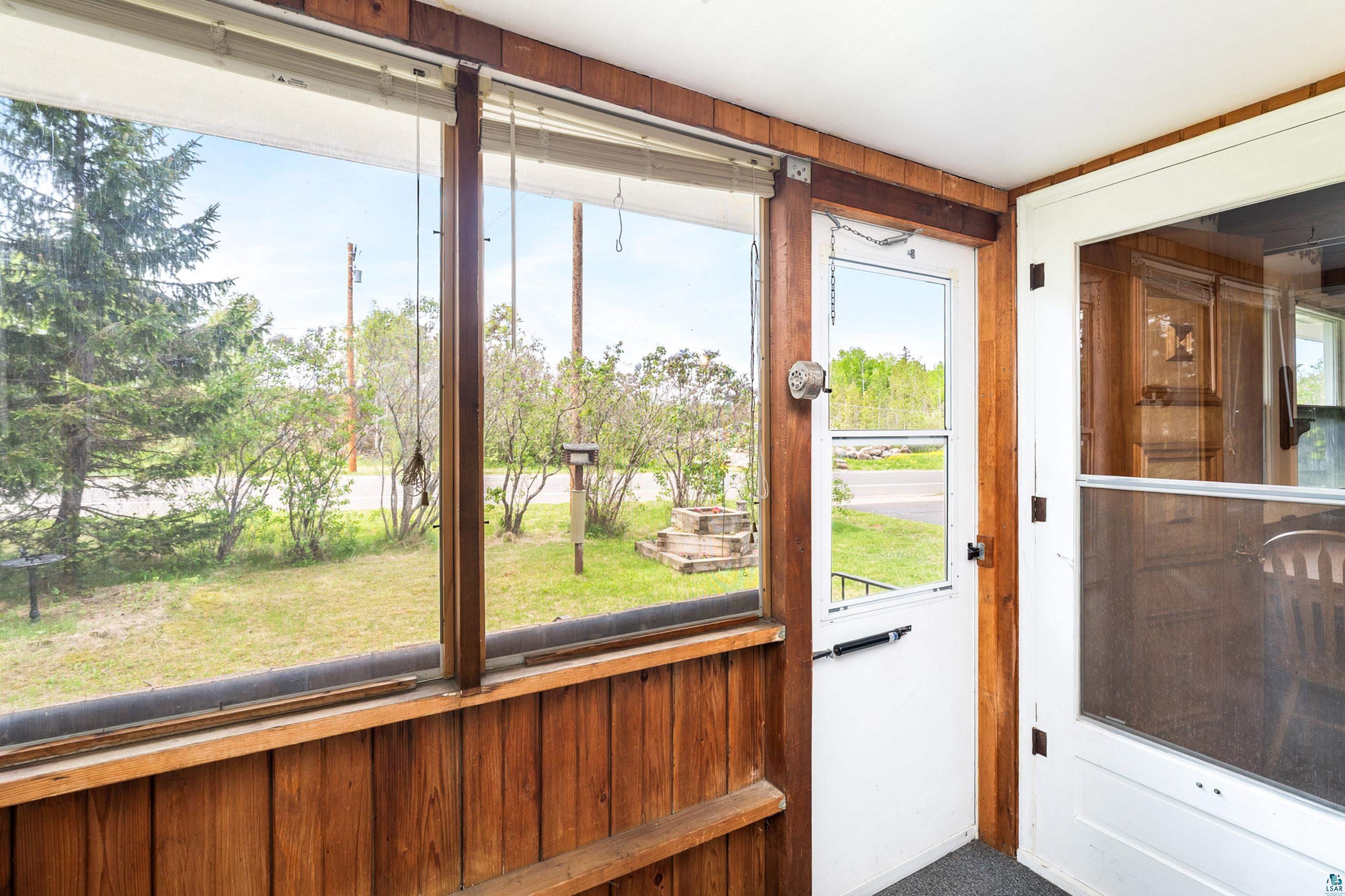 4808 Midway Road Duluth, MN 55811 - Photo 15 of 57 Screened-in porch featuring wood paneling, multiple window panels, and a white screen door