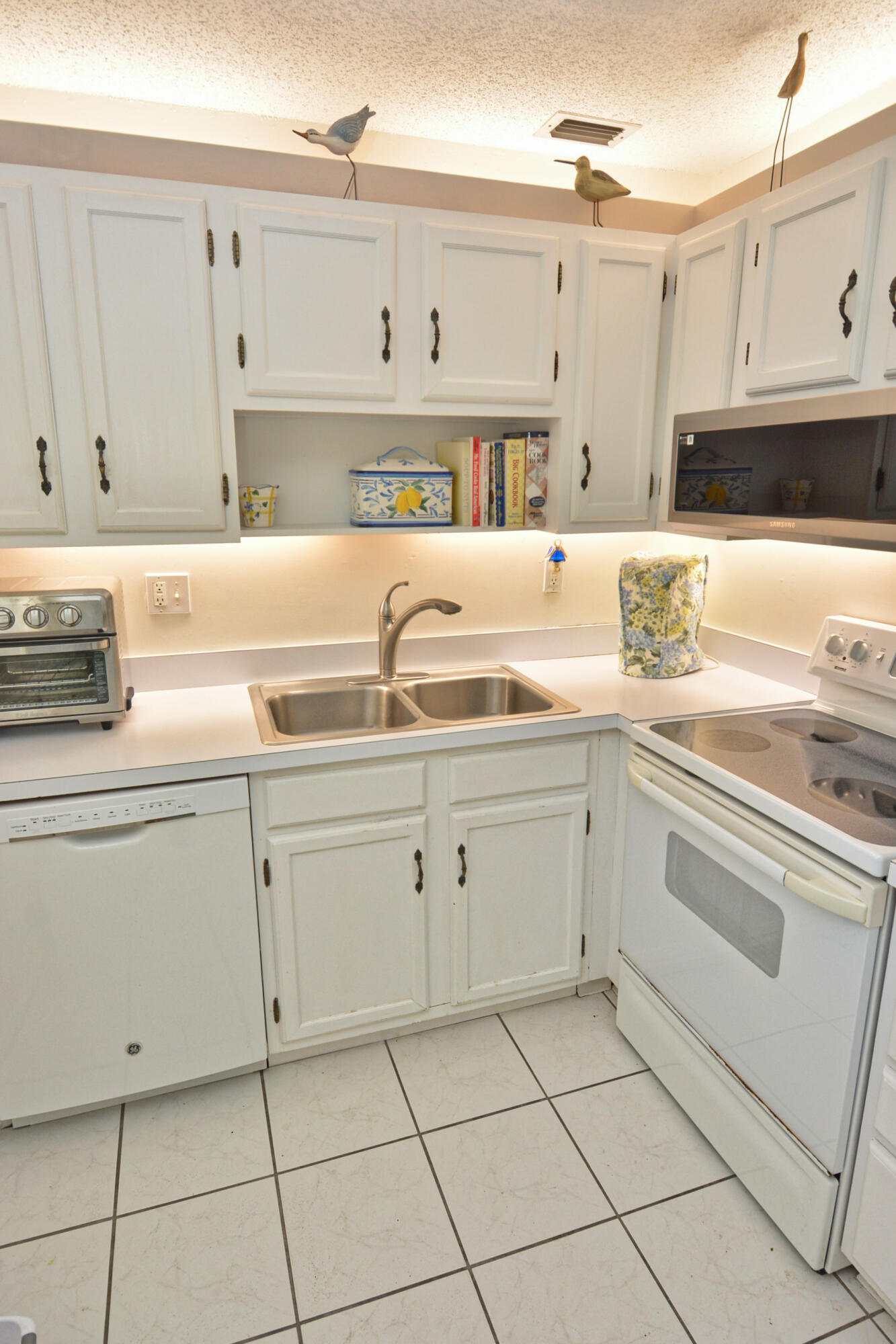 1225 Northwest 21st Street, Unit 203 Stuart, FL 34994 - Photo 14 of 44 a kitchen with cabinets appliances a sink and a counter top