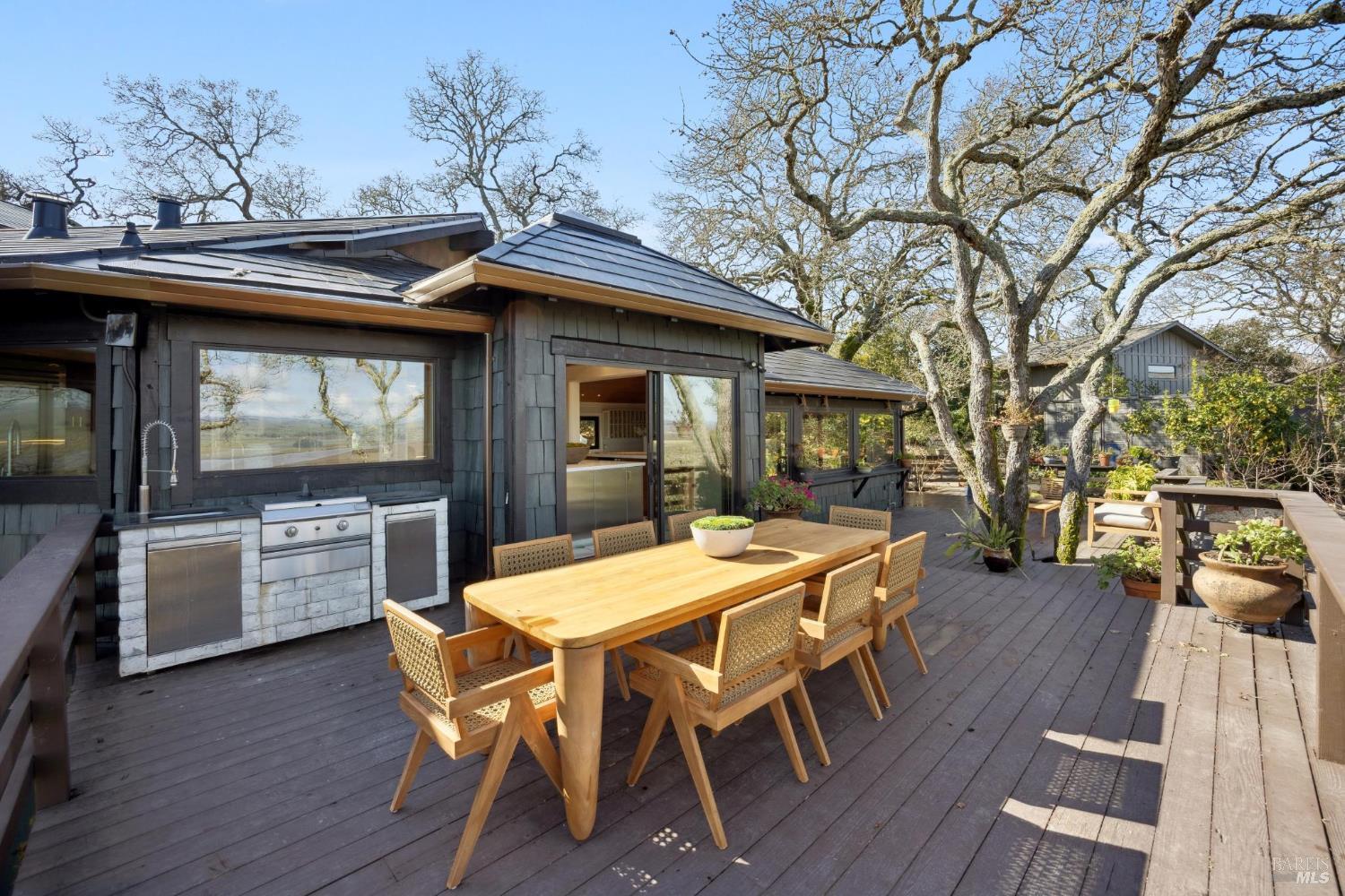160 Crest Road Novato, CA 94945 - Photo 79 of 85 a view of a patio with table and chairs with wooden floor and barbeque oven