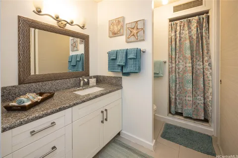 a bathroom with a granite countertop sink and a mirror