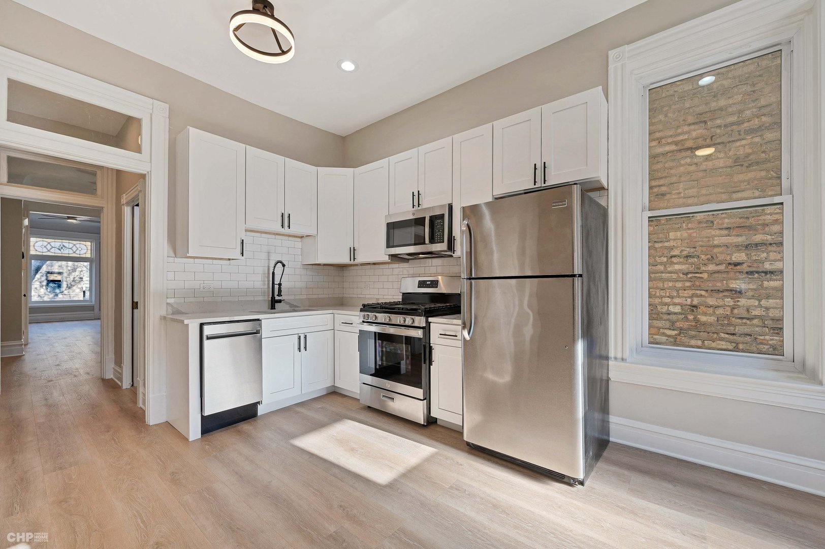 843 West Newport Avenue, Unit 2 Chicago, IL 60657 - Photo 16 of 26 a kitchen with a refrigerator sink and cabinets