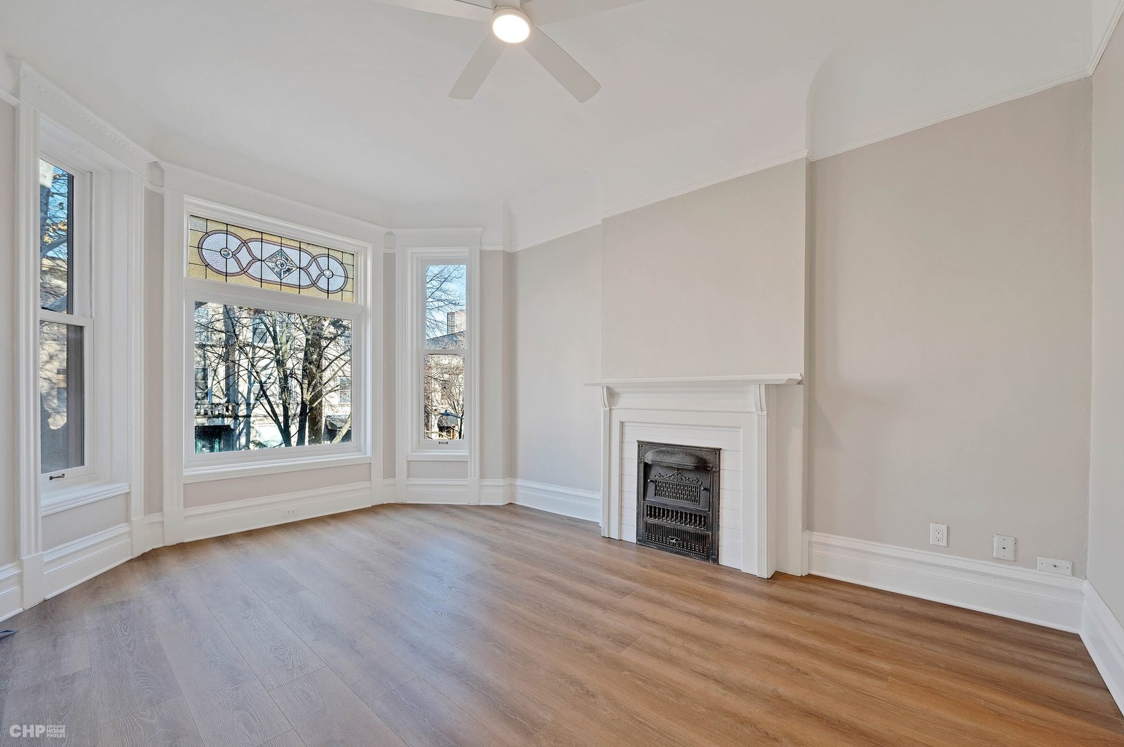 843 West Newport Avenue, Unit 2 Chicago, IL 60657 - Photo 2 of 26 wooden floor fireplace and windows in an empty room