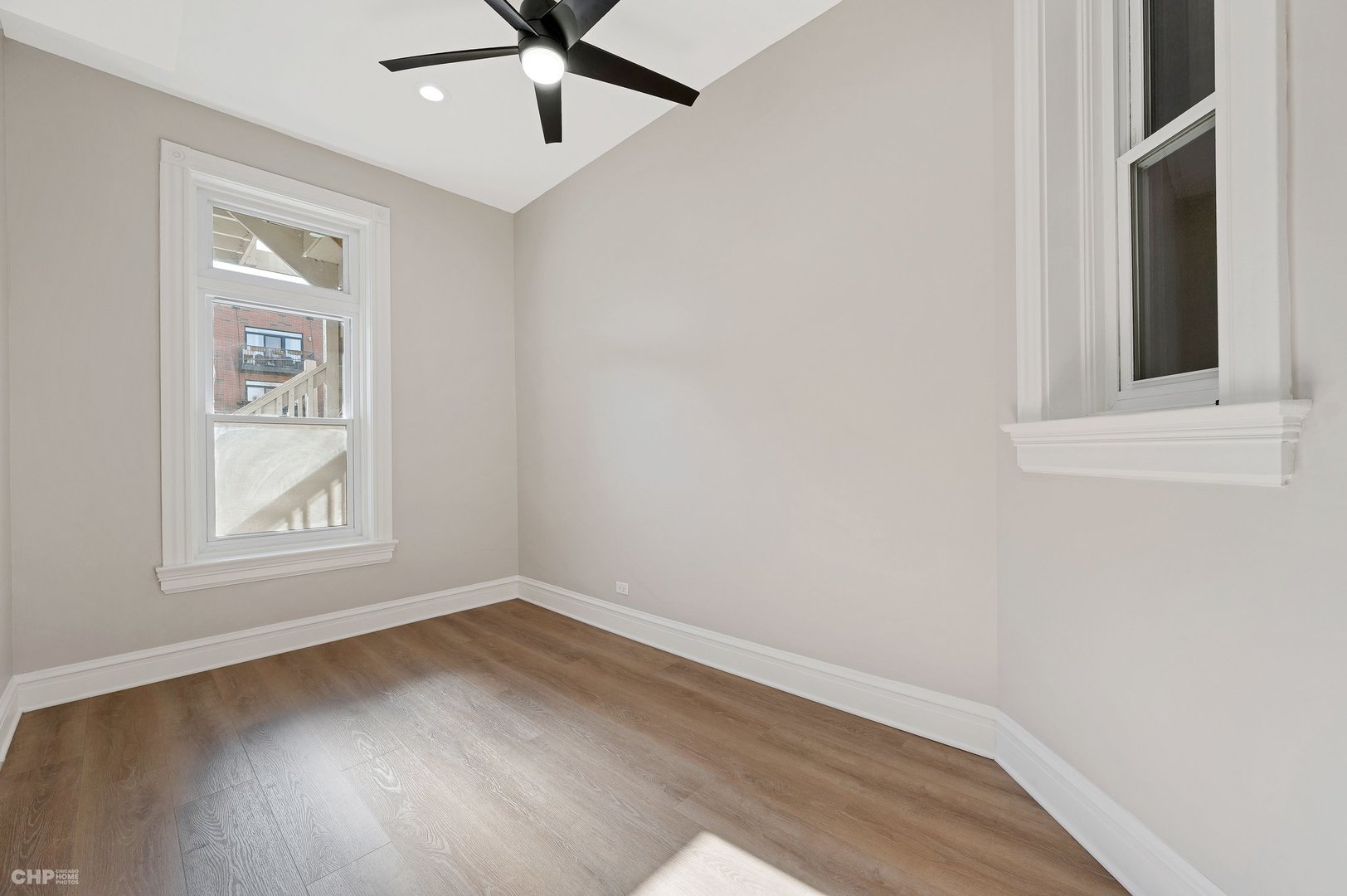 843 West Newport Avenue, Unit 2 Chicago, IL 60657 - Photo 21 of 26 an empty room with wooden floor fan and windows