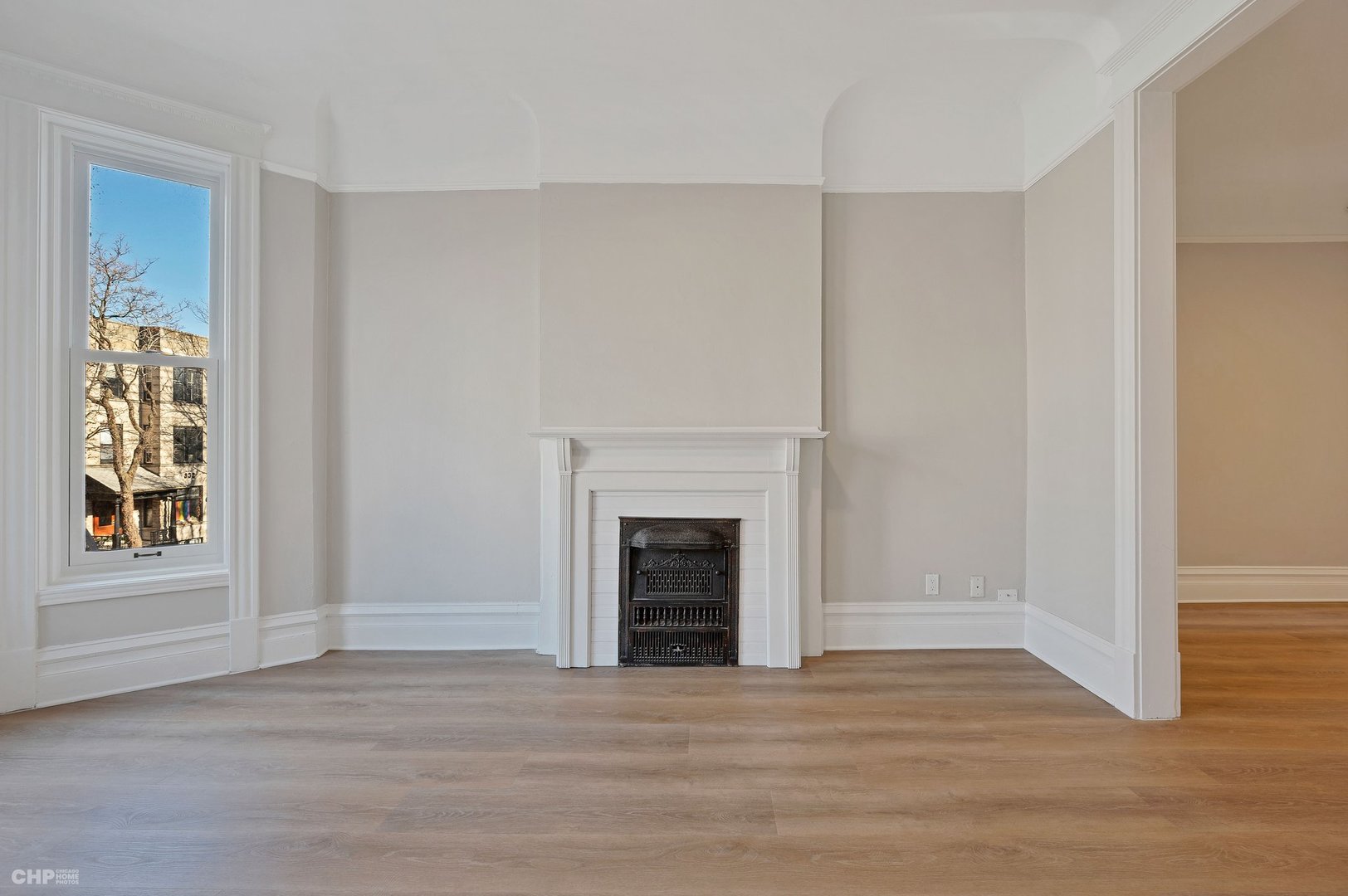 843 West Newport Avenue, Unit 2 Chicago, IL 60657 - Photo 3 of 26 a view of an empty room with wooden floor fireplace and a window