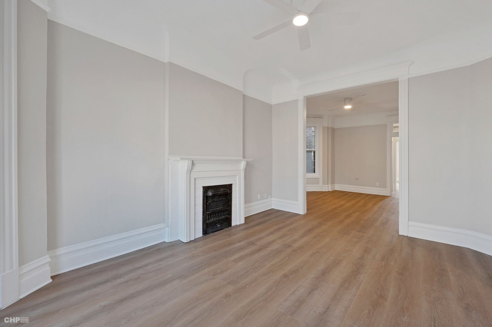 843 West Newport Avenue, Unit 2 Chicago, IL 60657 - Photo 4 of 26 a view of empty room with wooden floor and fireplace