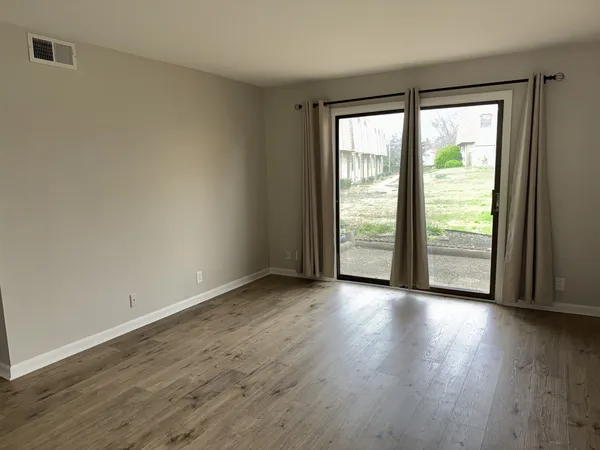 a view of a big room with wooden floor and doors