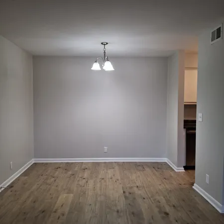 a view of an empty room with a chandelier fan