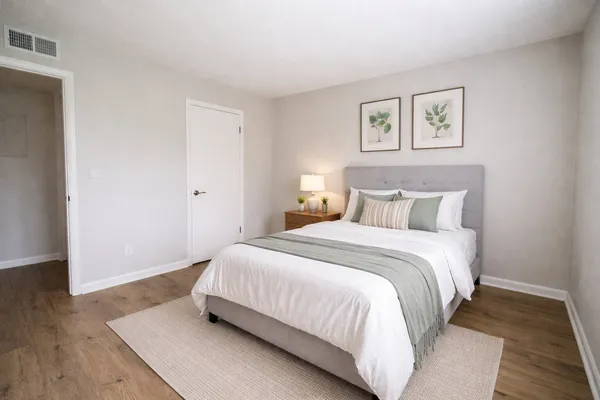 a bedroom with a bed and wooden floor