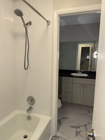 a en suite bathroom with a granite countertop sink and a mirror