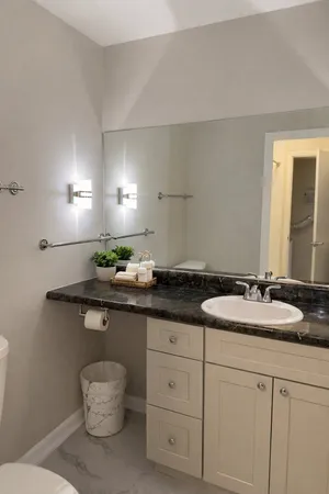 a bathroom with a granite countertop sink and a mirror