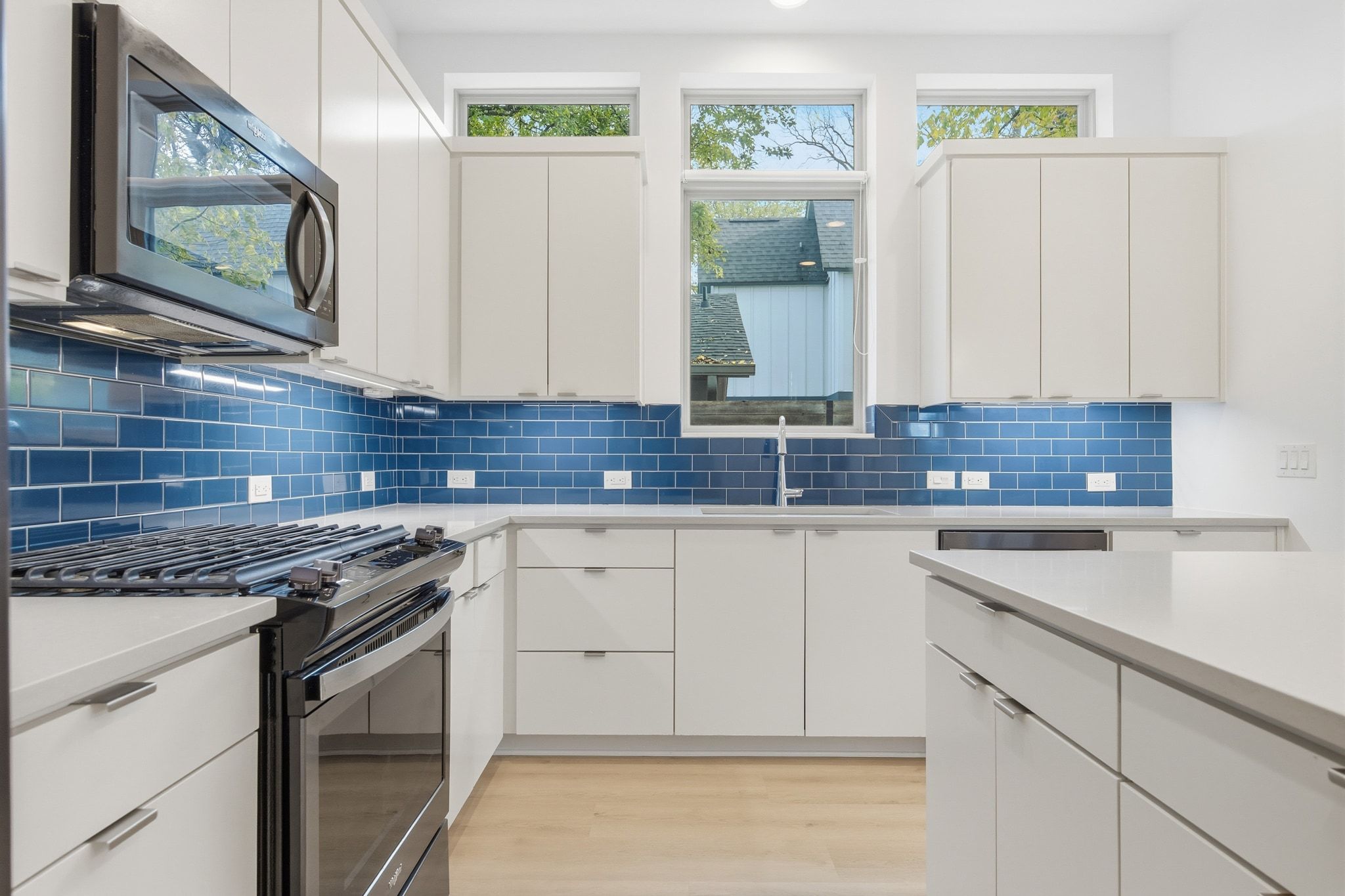 2811 Garwood Street, Unit B Austin, TX 78702 - Photo 10 of 24 Kitchen featuring stainless steel appliances, white cabinetry, modern cabinets, and light wood-style flooring