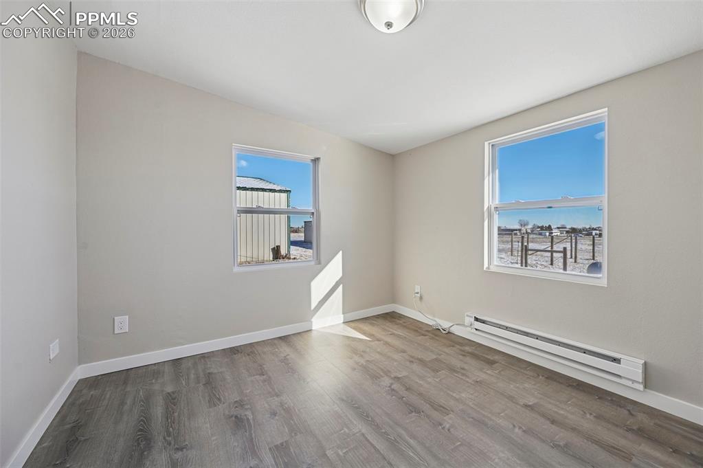 6315 Peerless Farms Road Peyton, CO 80831 - Photo 12 of 49 an empty room with wooden floor and windows