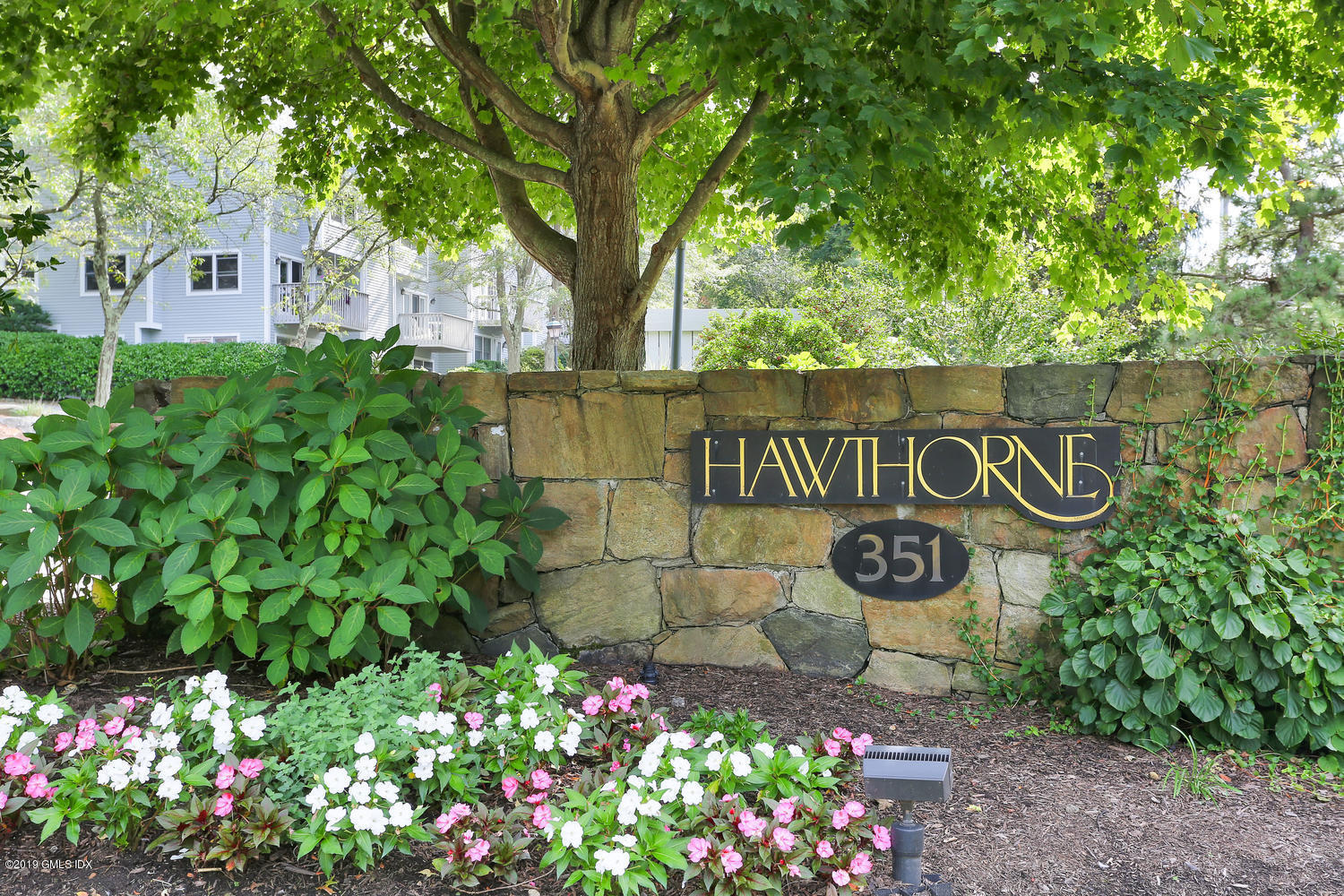 351 Pemberwick Road, Unit 205 Greenwich, CT 06831 - Photo 1 of 12 a sign that is in front of flowers