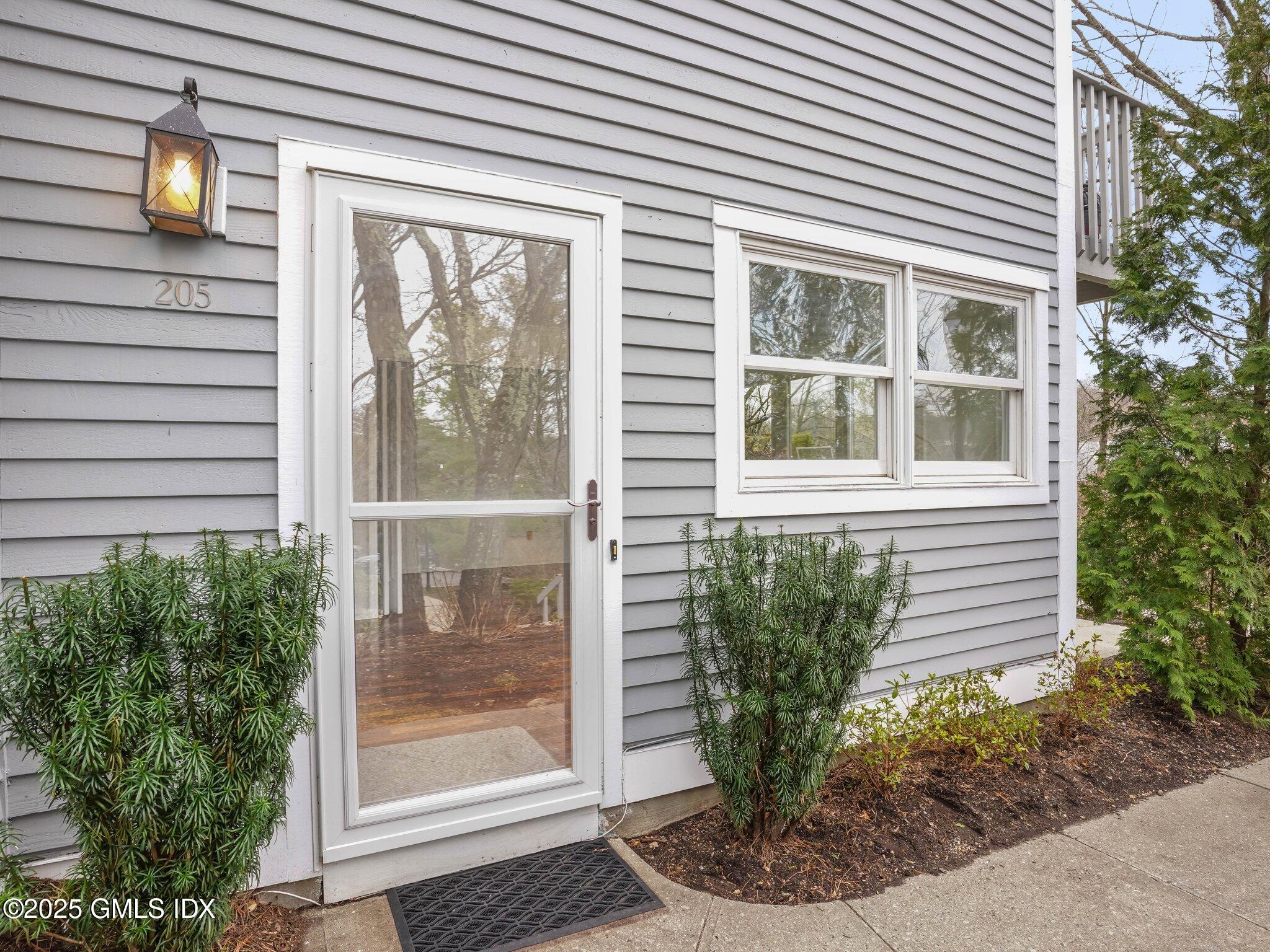 351 Pemberwick Road, Unit 205 Greenwich, CT 06831 - Photo 2 of 12 a front view of a house with garden