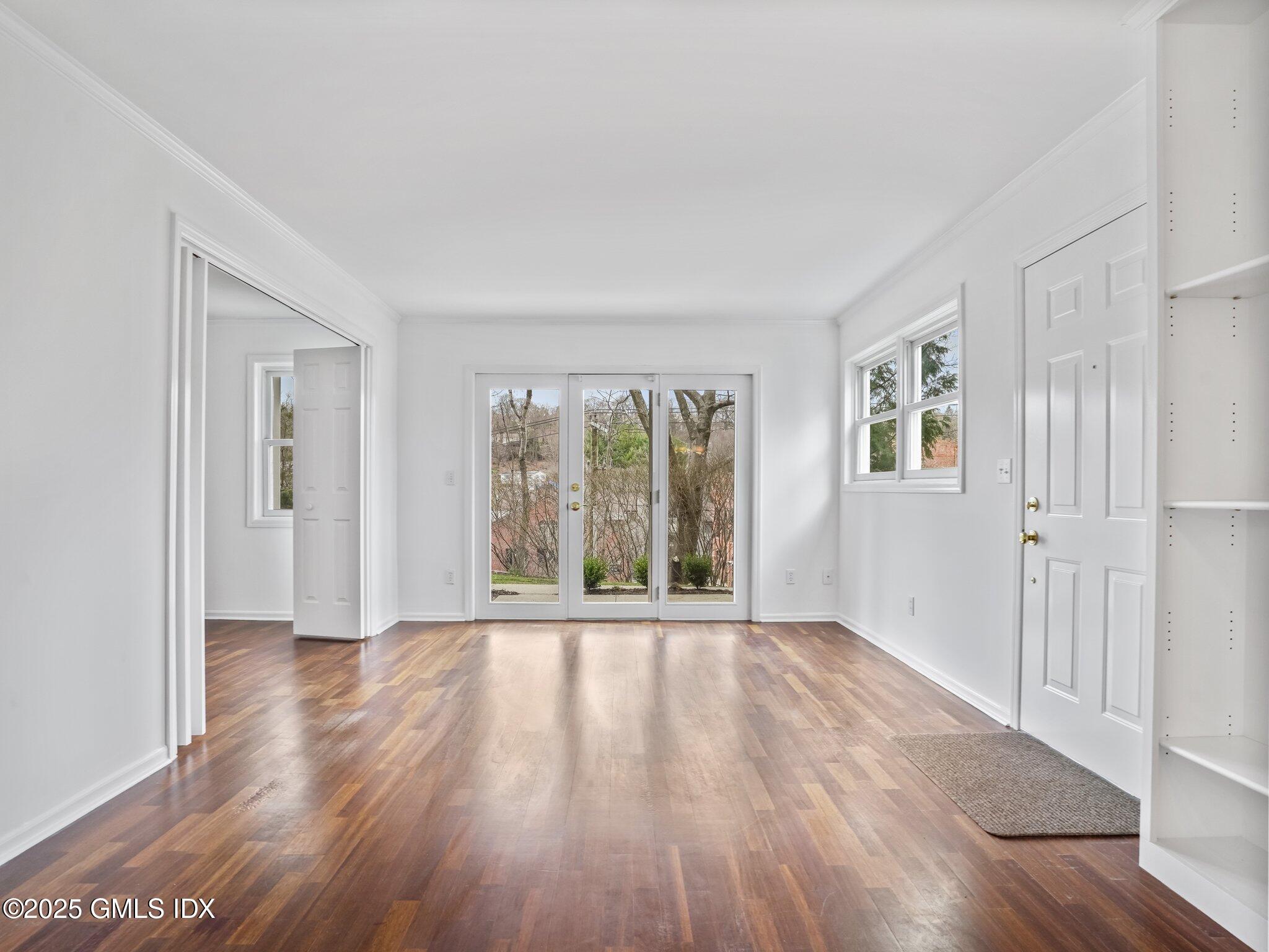 351 Pemberwick Road, Unit 205 Greenwich, CT 06831 - Photo 5 of 12 a view of an empty room with wooden floor and a window