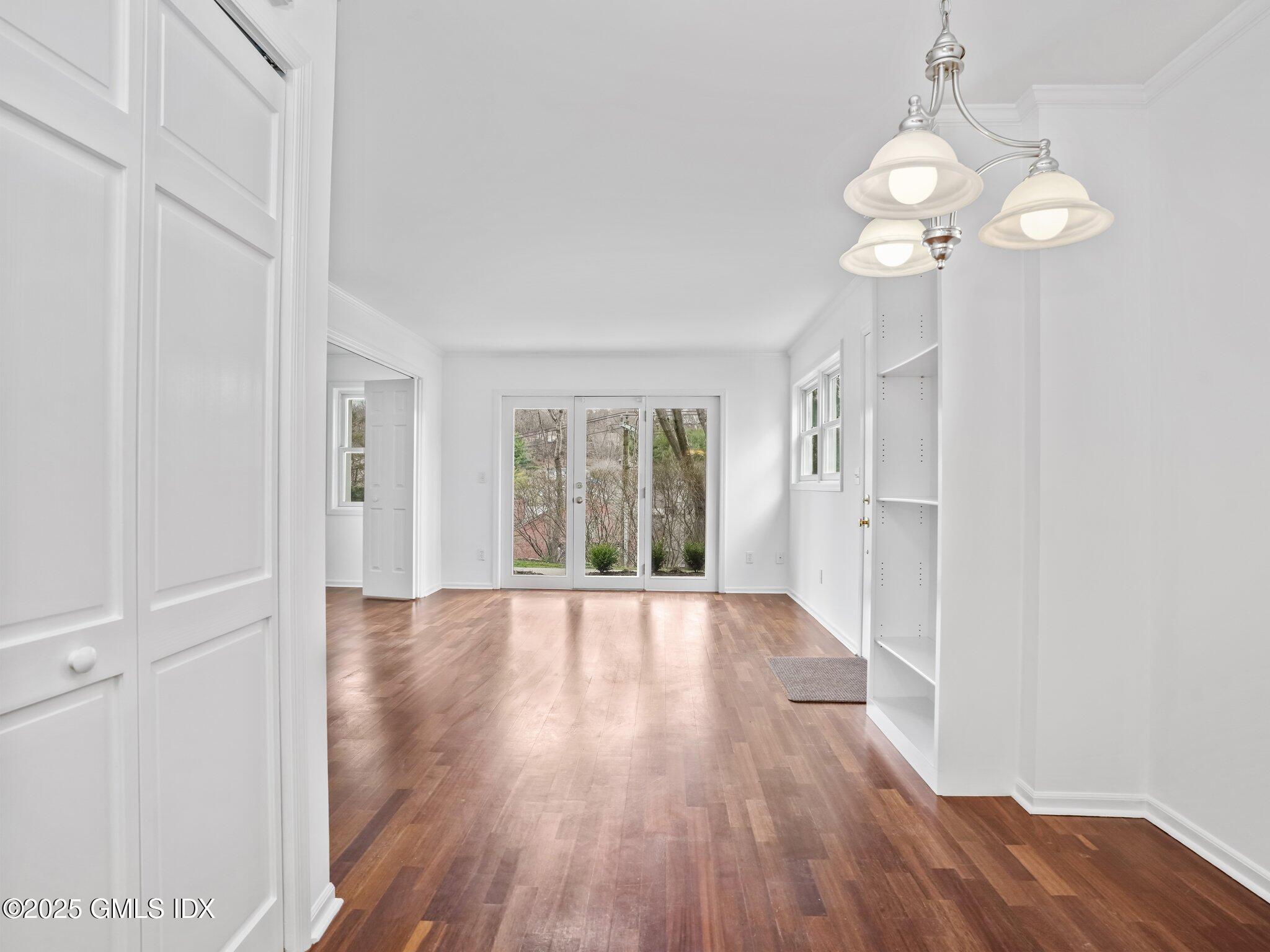 351 Pemberwick Road, Unit 205 Greenwich, CT 06831 - Photo 6 of 12 a view of an empty room with wooden floor and window