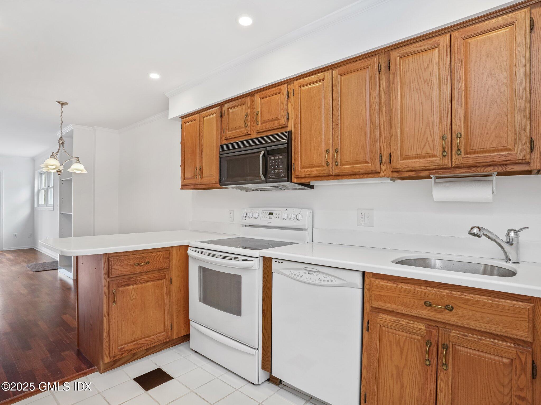 351 Pemberwick Road, Unit 205 Greenwich, CT 06831 - Photo 7 of 12 a kitchen with stainless steel appliances granite countertop a sink stove and microwave