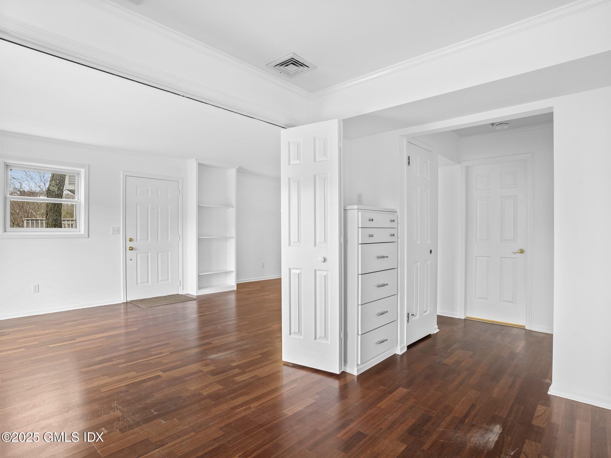 351 Pemberwick Road, Unit 205 Greenwich, CT 06831 - Photo 10 of 12 a view of an empty room with window and wooden floor