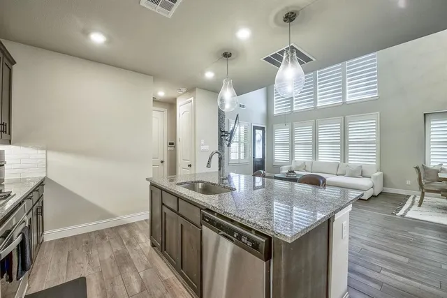 a kitchen with granite countertop kitchen island a stove a counter space and wooden floor