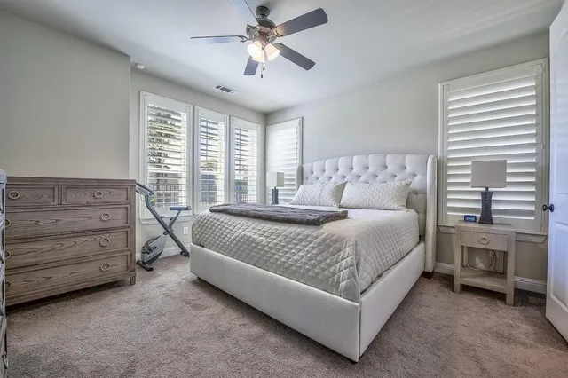 a spacious bedroom with a bed and a ceiling fan