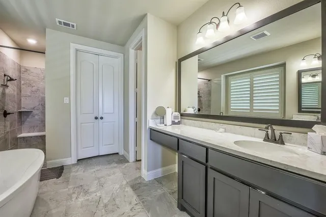 a spacious bathroom with a double vanity sink mirror and a bathtub