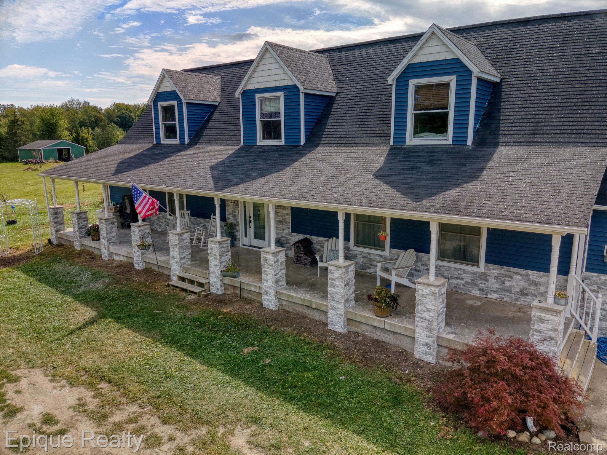 13265 Tibbets Road Memphis, MI 48041 - Photo 41 of 48 View of front facade featuring covered porch, stone siding, a front yard, and a shingled roof