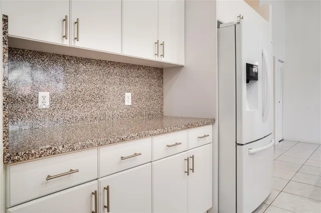 a kitchen with granite countertop white cabinets and stainless steel appliances