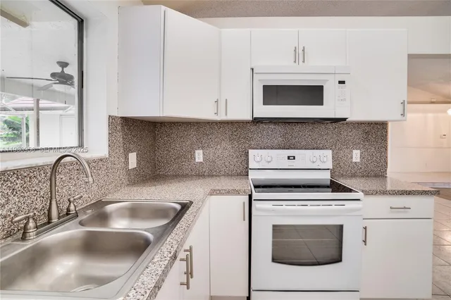 a kitchen with granite countertop cabinets stainless steel appliances and sink