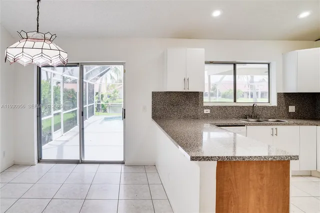 a kitchen with granite countertop a sink a stove and cabinets