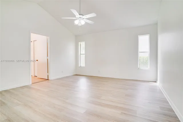an empty room with wooden floor and window