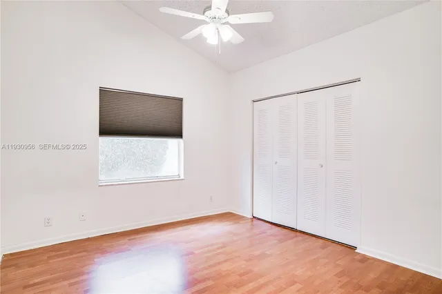 an empty room with a fan and a window