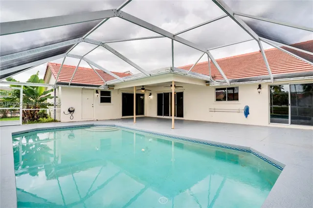 a view of a white house with swimming pool in front of it