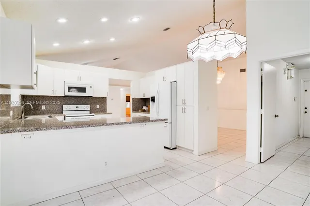 a kitchen with stainless steel appliances granite countertop a refrigerator a stove and a sink