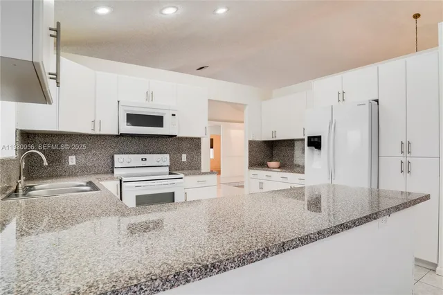 a kitchen with stainless steel appliances a stove a sink a microwave and cabinets