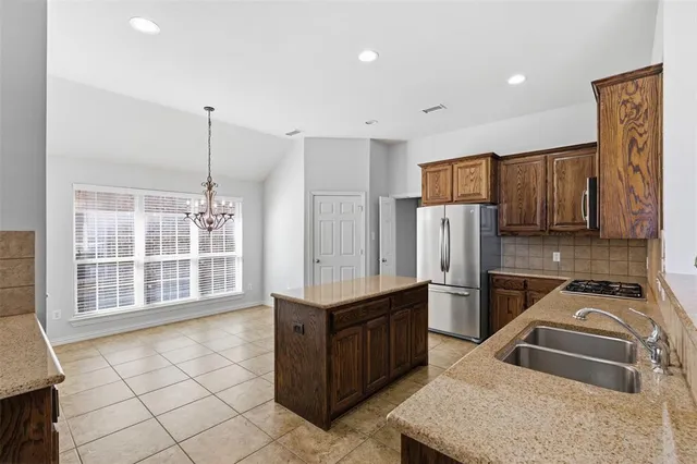 a kitchen that has a refrigerator a sink and a stove in it