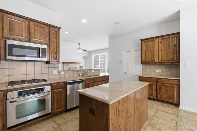 a kitchen with stainless steel appliances a stove sink microwave and cabinets