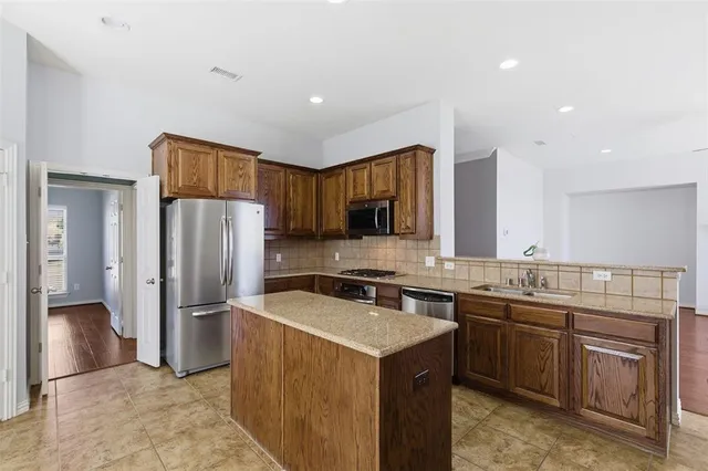 a kitchen that has a sink a stove and stainless steel appliances