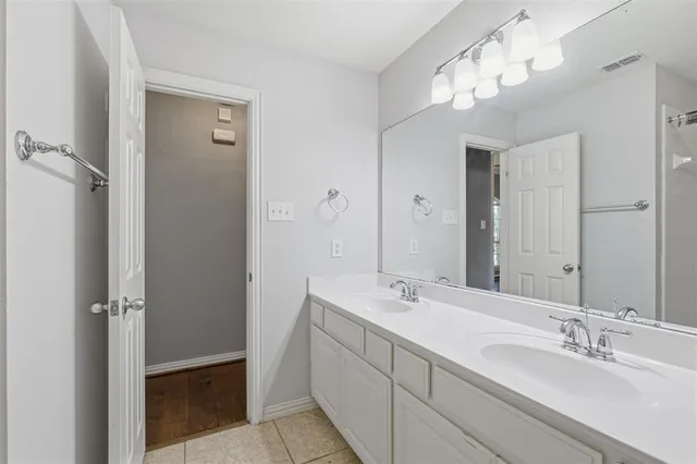 an empty room with a chandelier fan and windows