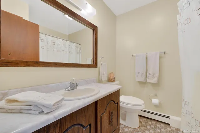 a bathroom with a granite countertop sink and a mirror with toilet