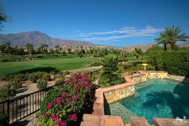 a view of a garden with a lot of flower plants and wooden fence