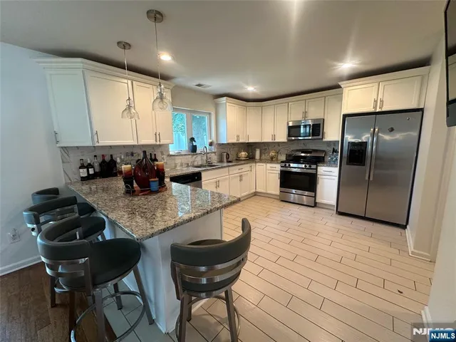 a kitchen with stainless steel appliances granite countertop a sink counter space cabinets and a counter top space