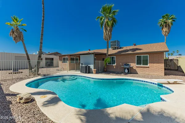 a view of a backyard with couches and swimming pool