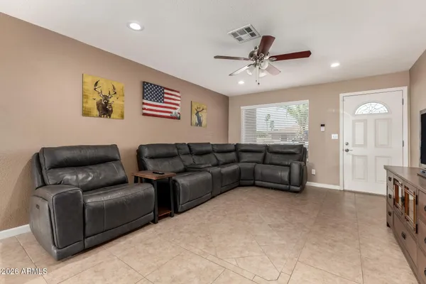 a living room with furniture and a ceiling fan
