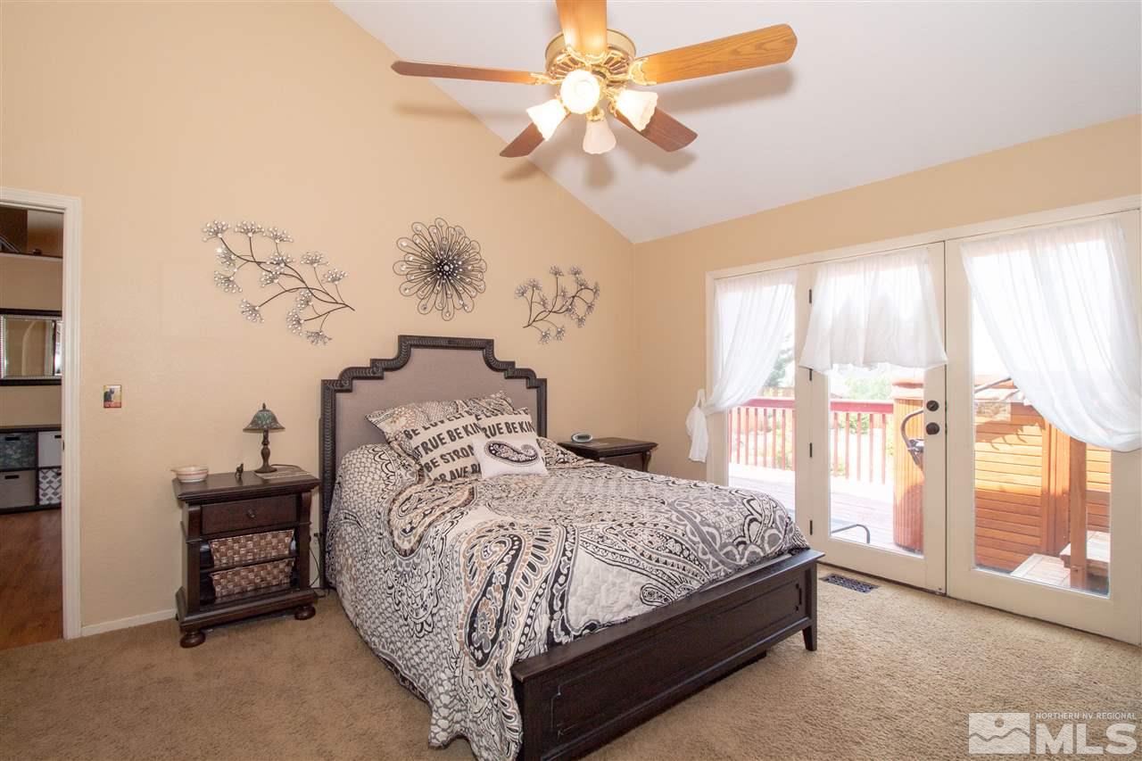 13335 Rim Rock Drive Reno, NV 89521 - Photo 11 of 25 a bedroom with a large bed and a chandelier fan