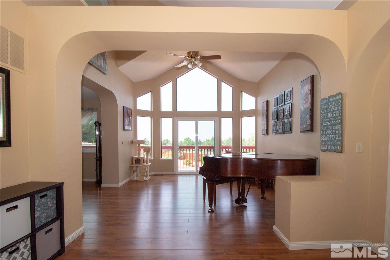 13335 Rim Rock Drive Reno, NV 89521 - Photo 3 of 25 a dining room with wooden floor a chandelier a glass table and chairs