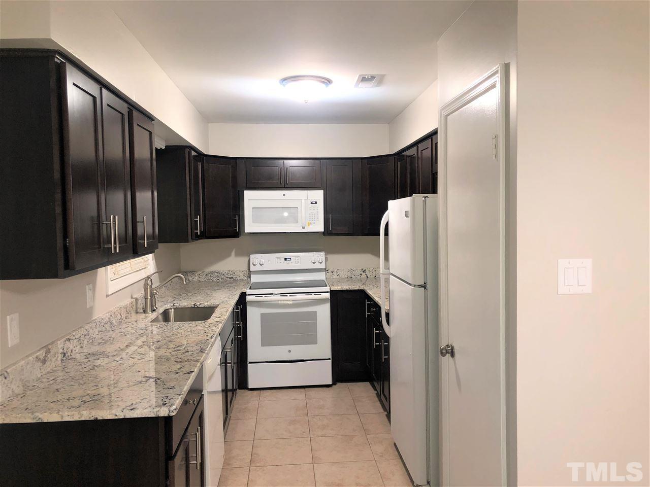 4244 Lake Ridge Drive, Unit 12B Raleigh, NC 27604 - Photo 15 of 28 a kitchen with granite countertop a refrigerator and stove