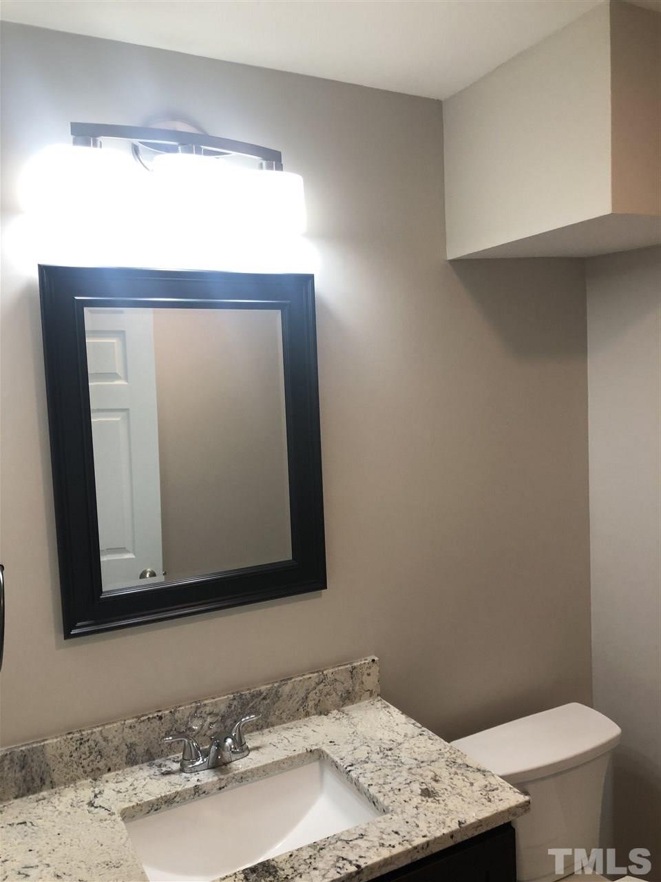 4244 Lake Ridge Drive, Unit 12B Raleigh, NC 27604 - Photo 7 of 28 a bathroom with a granite countertop sink and a mirror