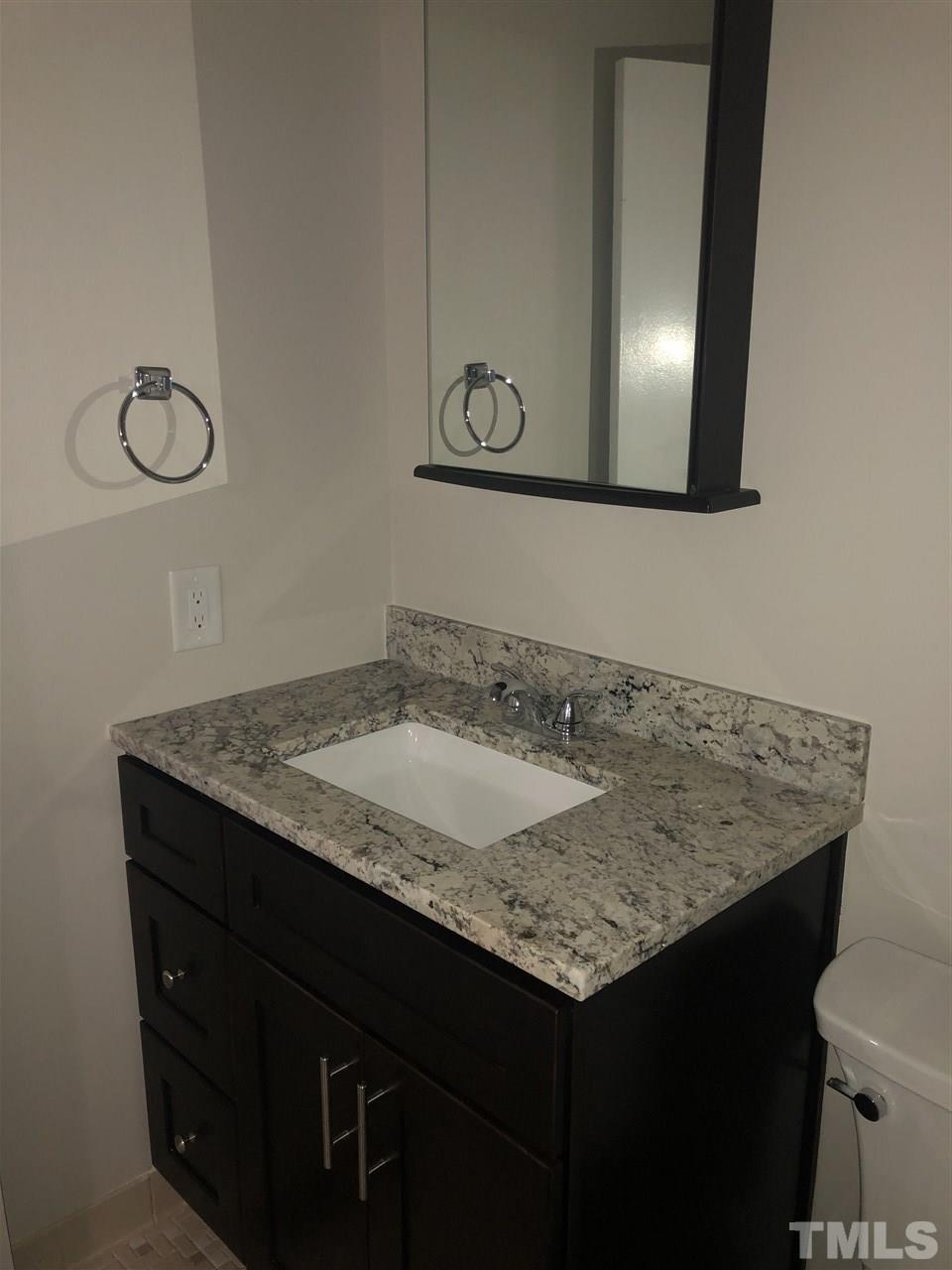 4244 Lake Ridge Drive, Unit 12B Raleigh, NC 27604 - Photo 8 of 28 a bathroom with a granite countertop sink and a mirror